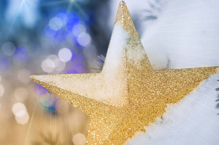 Golden sparkle star in snow as Christmas decorationの写真素材