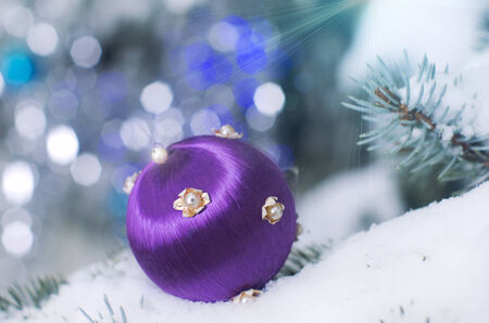 Christmas decoration ball on snowy tree on blue backgroundの写真素材