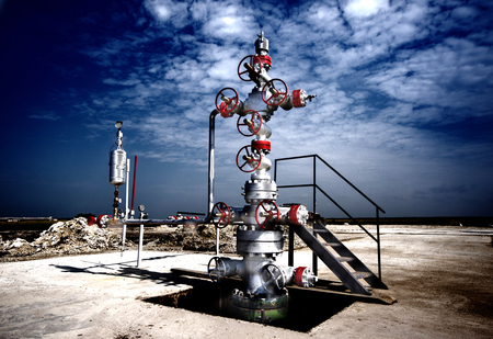 Oil drilling platform in the plain with dynamic blue sky in backgroundの写真素材