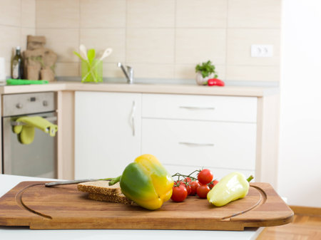 Fresh vegetable with wholemeal bread on wooden board on kitchen countertopの写真素材