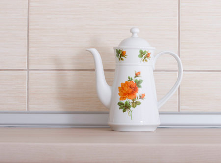 Vintage teapot on wooden kitchen countertop with beige tilesの写真素材