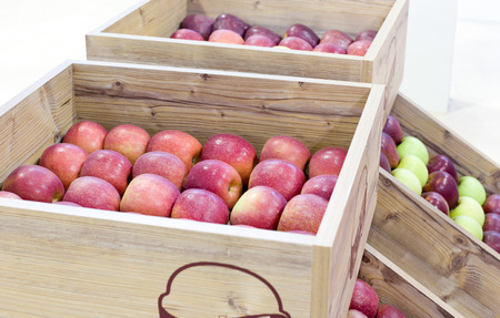 Red delicious apples arranged in wooden crates over white backgroundの写真素材