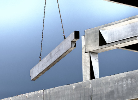 Crane lifting concrete truss for installing in building skeletonの写真素材