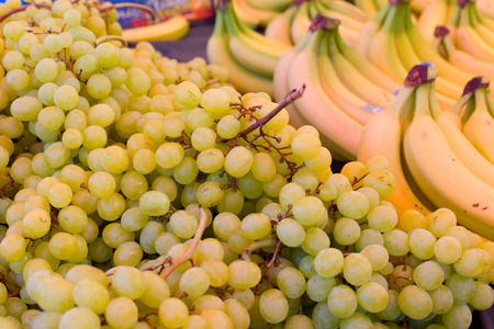 Close up of white grapes and bananas at green marketの写真素材