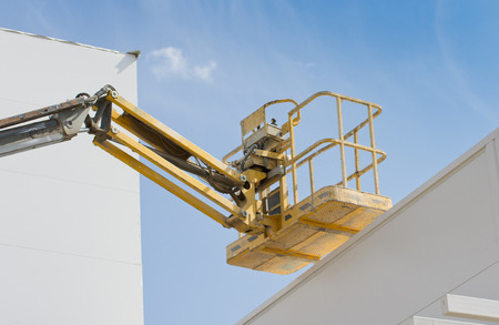 Construction lift platform with cage for worker safety standing high in the air
