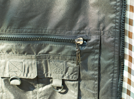 Close up of zipper on pocket of olive green vest