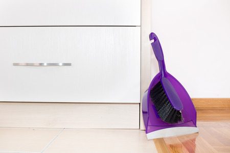 Plastic shovel with brush set against kitchen furnitureの写真素材