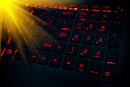 Red backlight on the modern keyboard of gaming laptop in the darkの写真素材