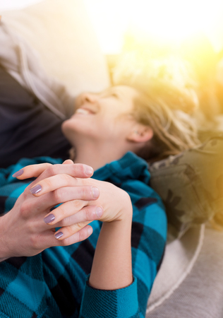 Young couple in love. Close up of hands holding each other. Girl lying on his lap and smilingの写真素材