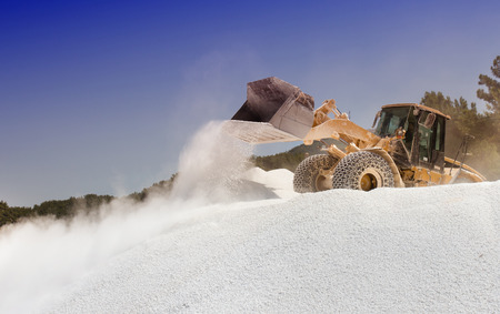 Bulldozer working on the top of huge pile of marble pebble on Thassos in Greece
