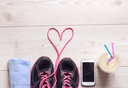 Sport concept, healthy lifestyle. Female sportshoes, towel, cell phone and smoothie in the cup on the floor, ready for jogging. Top viewの写真素材