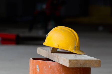 Close up of yellow helmet on the plank at construction site