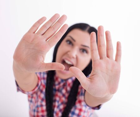 Young girl showing stop sign with two palms in foreground