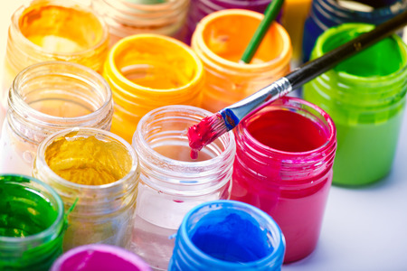 Close up of painting brush on the plastic jars of colors on white background. Art and craft conceptの写真素材