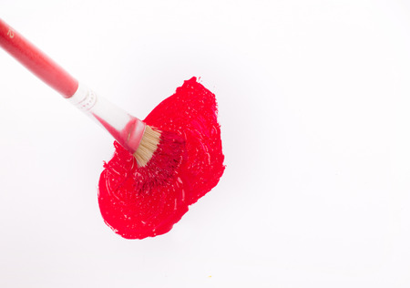 Paint brush making blot with red watercolor on white backgroundの写真素材