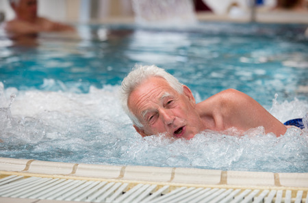 Senior man resting in hot tub in spa resortの写真素材