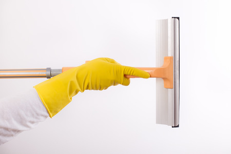 Woman with rubber gloves holding squeegee for windows cleaning, isolated on white background