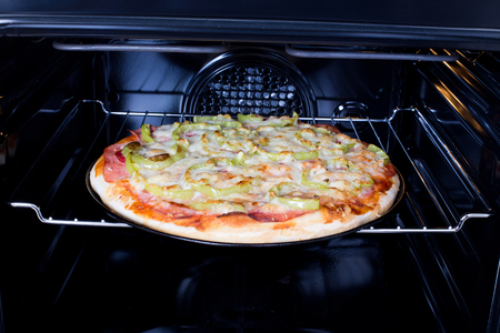 Baked hot homemade pizza in open oven の写真素材