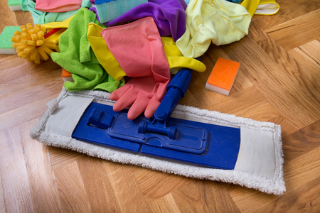 Close up of mop and other cleaning equipment on parquet floor. House keeping conceptの写真素材