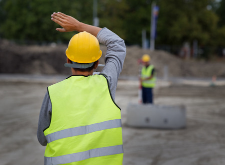 Surveyor engineers working with theodolite on road construction site