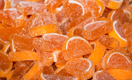 Fruity orange slices of jelly beans on pile. Close up of confectionery dessertsの写真素材