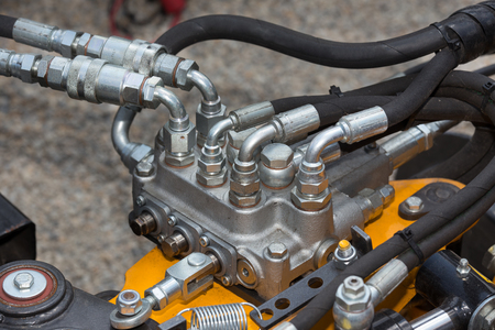 Close up of pipe system of hydraulic valves in agricultural machinery