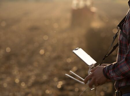 Close up of remote control with tablet for drone in farmer's hands in field. High technology innovations for increasing productivity in agricultureの写真素材