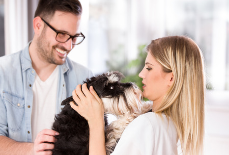 Cute dog loves his young veterinarian. Owner bringing him to examination in veterinary clinic 