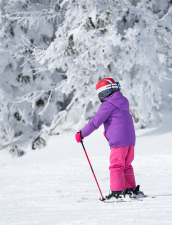 Side view of child skiing on peak of mountain. Winter sport and recreation conceptの写真素材