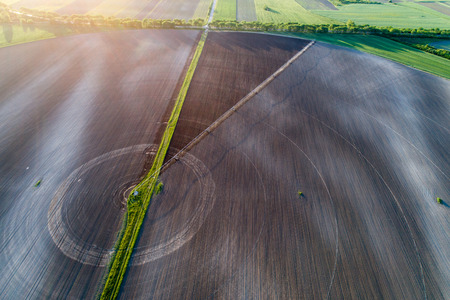 Aerial image of agricultural field with center pivot irrigation systems forming round shape field,...