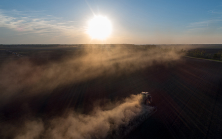 Aerial image of tractor harrowing soil in plains shoot from droneの写真素材