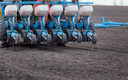 Rear view of tractors with seeder driving on field in springの写真素材