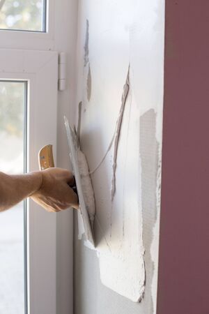 Craftsman skimming part of wall beside window.Home renovation conceptの写真素材