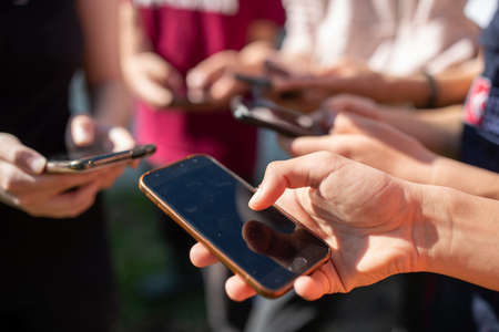 Close up of group of teenages using mobile phones. Social networking concept