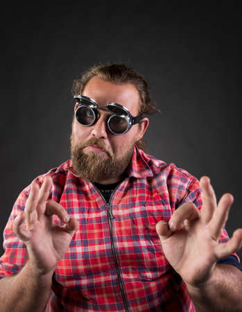 Portrait of funny man with flying goggles showing ok sign and looking at camera.