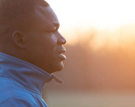 Side view of a black man in sportswear preparing for his workout morning routine.の写真素材