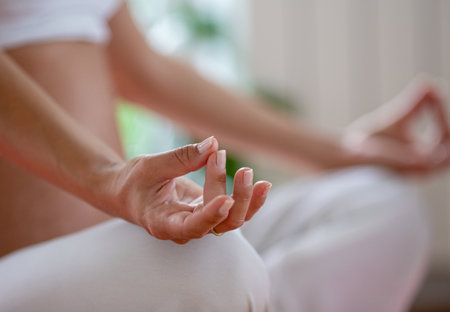 Close up of female hand meditating in yoga position on floorの写真素材