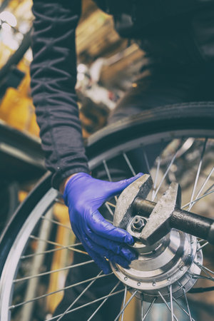 Cycling technician repairing and maintaining bike and wheel in workshopの写真素材