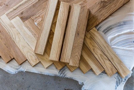 Top view of parquet boards installing in herringbone arrangement on glue, home flooring concept