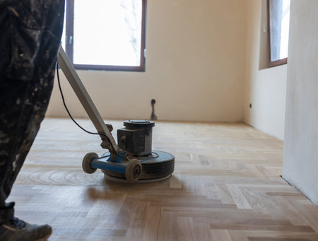 Craftsman polishing parquet floor with machine. Home renovation conceptの写真素材