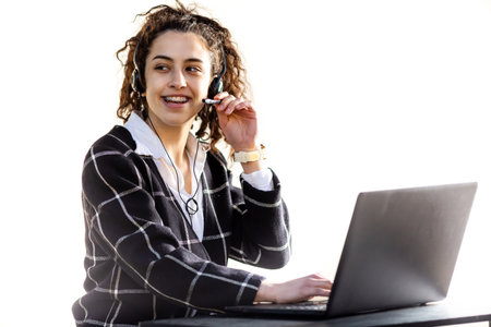Pretty young woman with headphones and microphone smiling and working on customer service position, isolated on white backgroundの写真素材