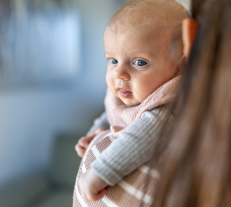 Portrait of adorable infant on mother's shoulder. Mothernity love and care conceptの写真素材