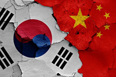 flags of South Korea and China painted on cracked wallの写真素材