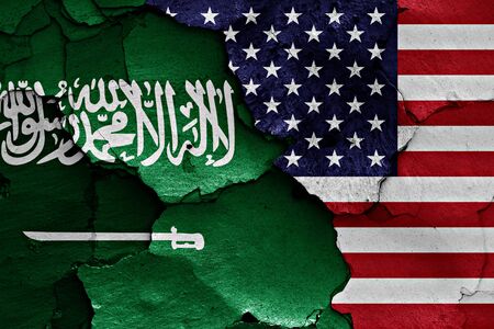 flags of Saudi Arabia and USA painted on cracked wallの写真素材