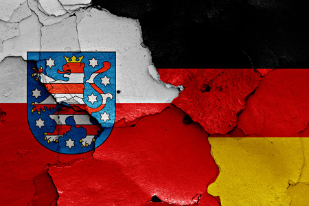 flags of Thuringia and Germany painted on cracked wallの写真素材
