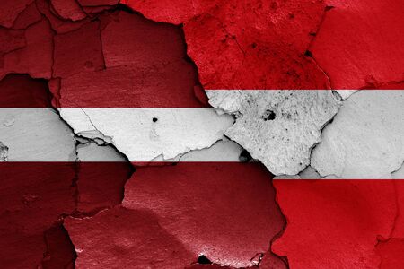 flags of Latvia and Austria painted on cracked wallの写真素材