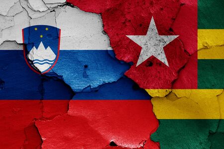 flags of Slovenia and Togo painted on cracked wallの写真素材