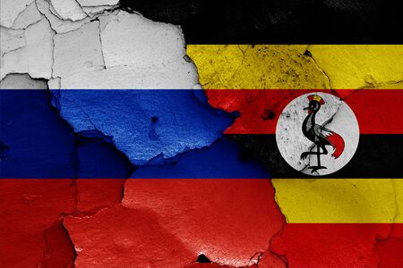 flags of Russia and Uganda painted on cracked wallの写真素材