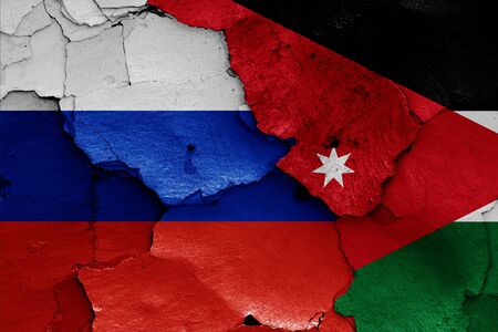 flags of Russia and Jordan painted on cracked wallの写真素材
