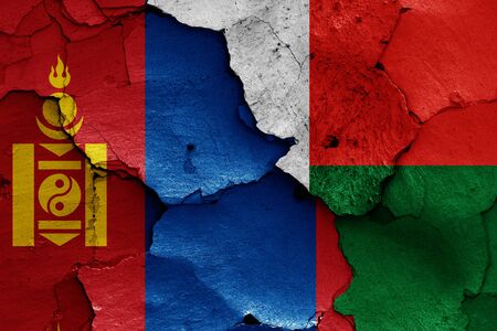 flags of Mongolia and Madagascar painted on cracked wallの写真素材